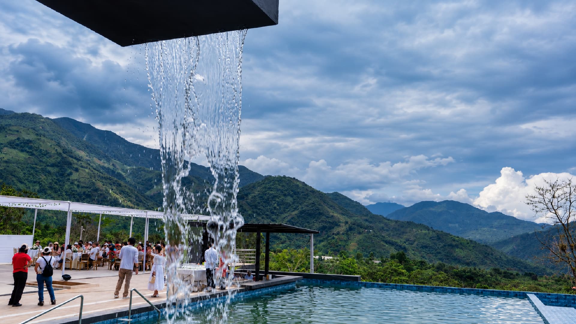 Piscina de Zagari Resort Club con cascada frente a las montañas